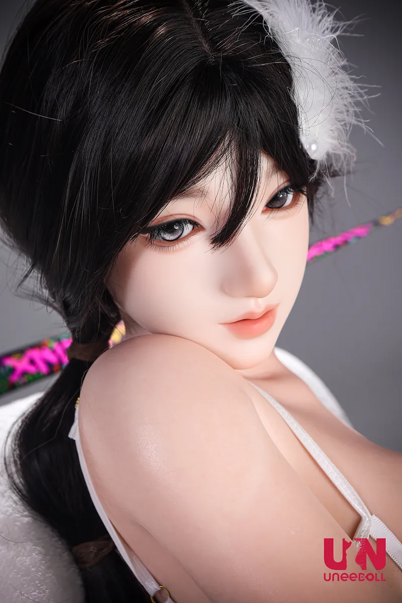 Close-up of Aurora's face, with a dark side braid, white feather accessory, and custom eyes