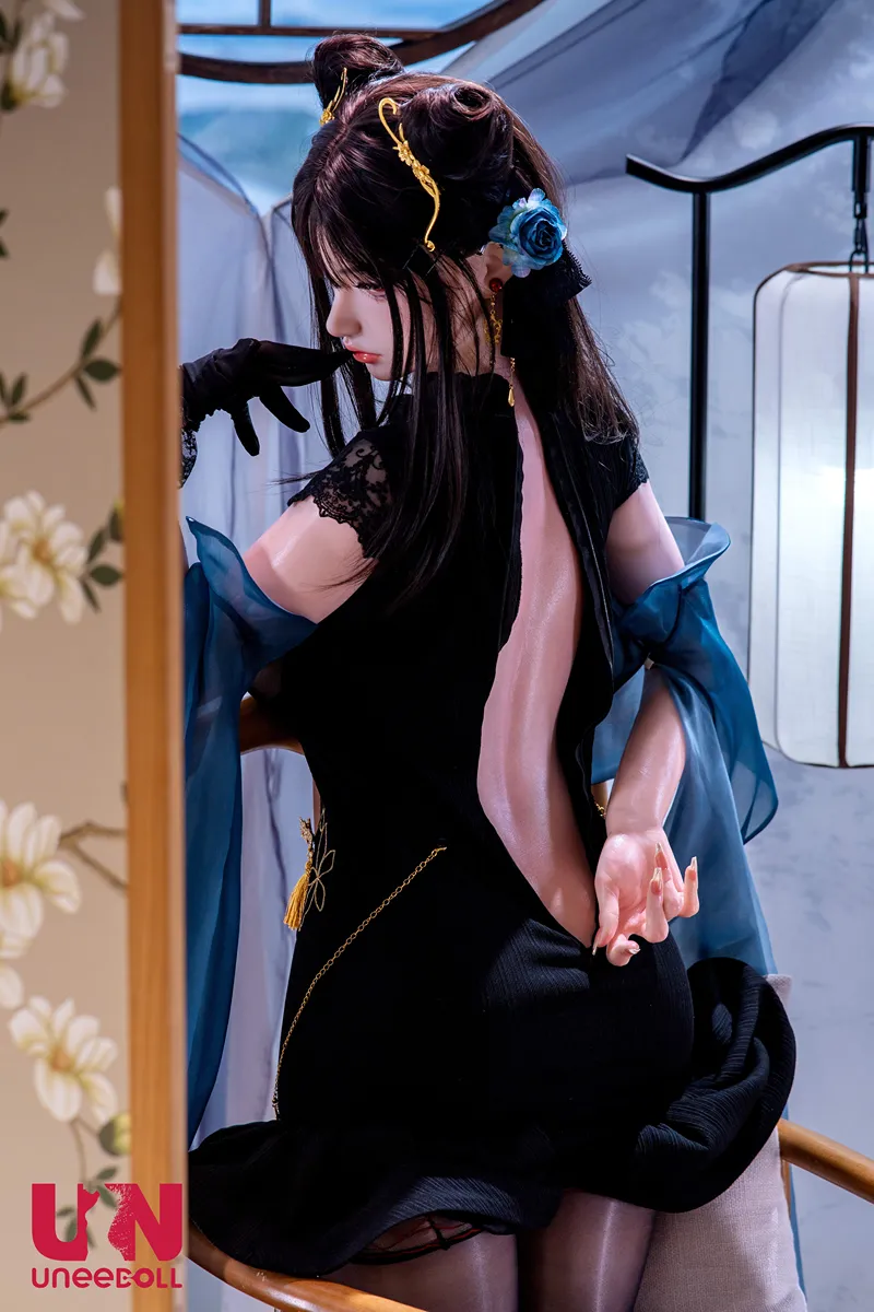 Ninghe (Lilith) est agenouillée sur la chaise en bois et regarde l’objectif par-dessus son épaule en tirant la fermeture éclair arrière de sa robe